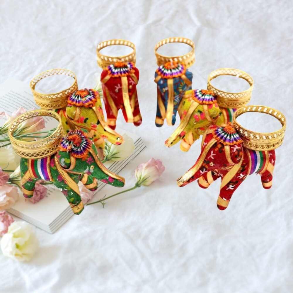 Handmade elephant tea light candle holders in vibrant purple, orange, and pink fabric with golden detailing, glowing candles, and festive Diwali décor on a decorative tabletop.